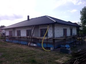 Pohled ze zahrady. Tmavé pruhy jsou připravené niky pro fasádní obklad