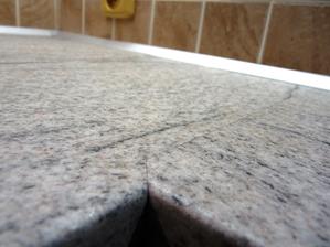 Detail spoje desky s těsnící AL lištou v pozadí.