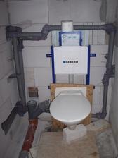 WC - dočasná mísa přichycená na osb desku, aby se nepoškodily nějaké šroubky či co, když ještě není geberit obezděný (velká finta :-D)