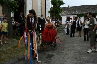starý vesnický zvyk - ženich do chomoutu, kouli na nohu, nevěsta bič do ruky a na trakař