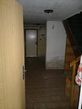 Vstup do domu, spodní chodba, naproti dveře do budoucí prádelny a napravo schody do obytného patra