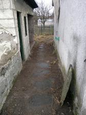 Průchod mezi přístavbou a bývalým kotcem pro psy/králíkárnou/skladištěm bordelu/nebo co to bylo