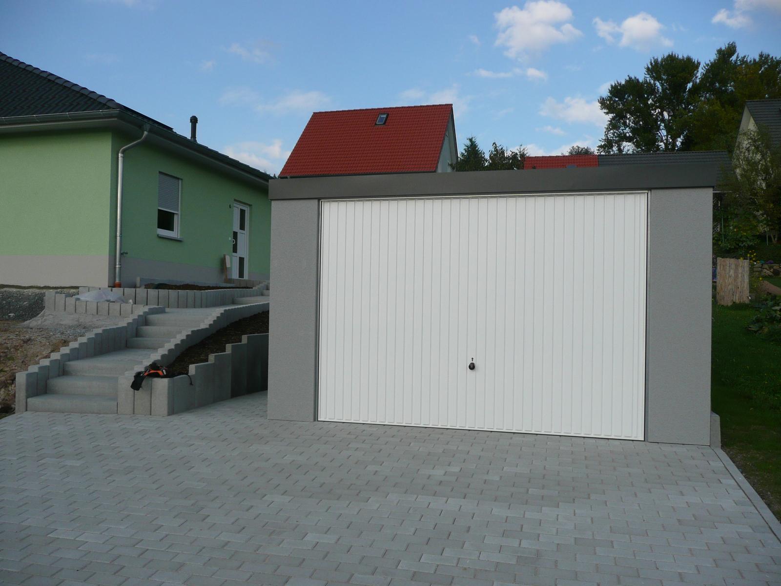 Montované garáže GARDEON - Montovaná garáž so šedou omietkou a bielou bránou