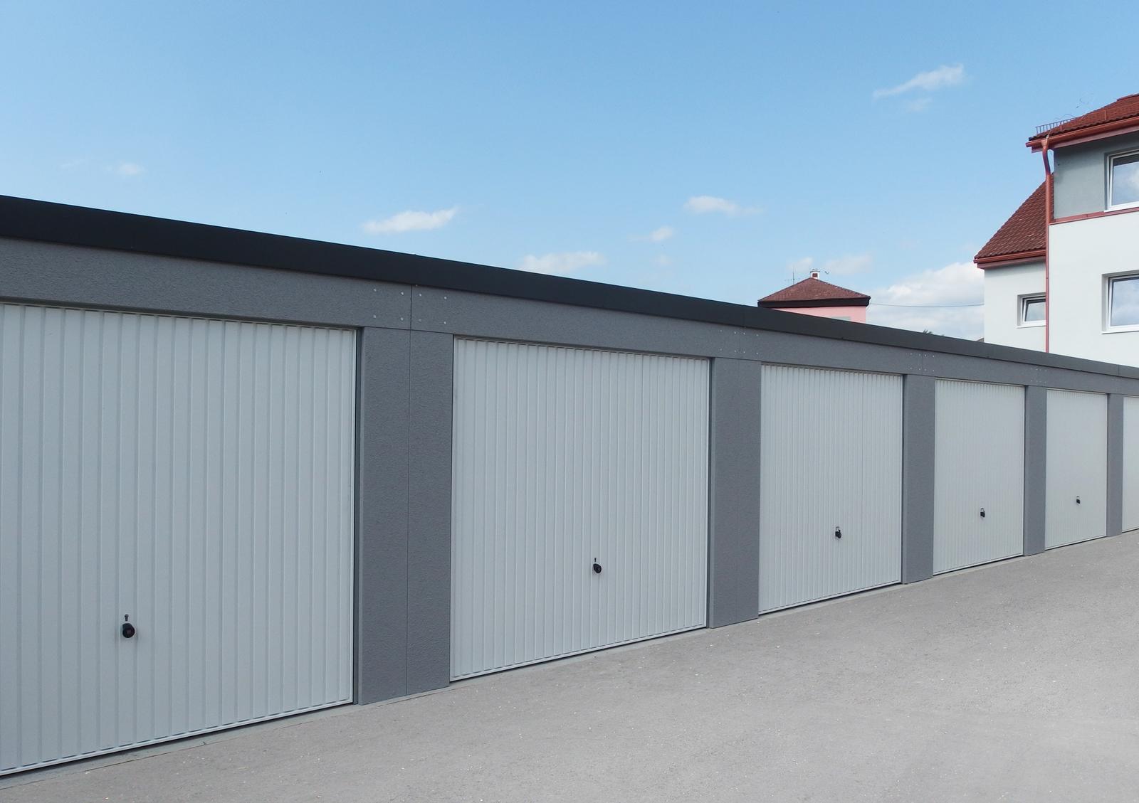 Montované garáže GARDEON - Radové garáže v šedej omietke s bielymi výklopnými bránami
