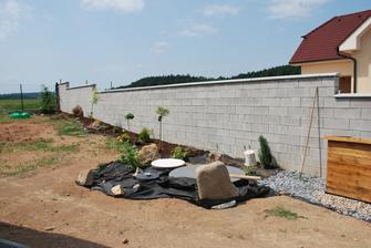 dokončení záhonu podél zdi, všude už bude jen tráva.. ještě přijdou kamínky kolem čistírny, vykukuje Montíka bouda