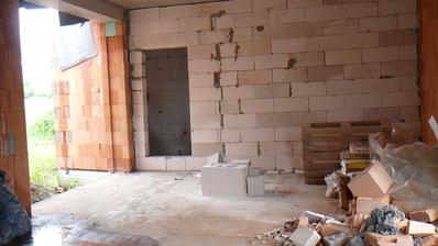 pohled z kuchyně přes obývací prostor na stěnu ložnice a dveře do šatny