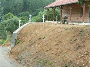 Srovnaný terén od silnice a sloupky nachystané na zábradlí (v této chvíli už ho máme, stejné jako u zadní zdi)