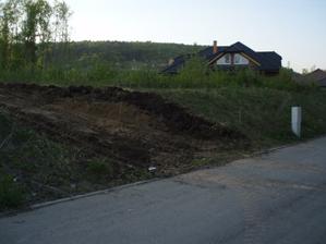 bagr vytvořil i nájezd na pozemek. Musíme ho nějak zpevnit, po dešti se tam vše boří. Sklon se upraví podle výšky carportu dodatečně.